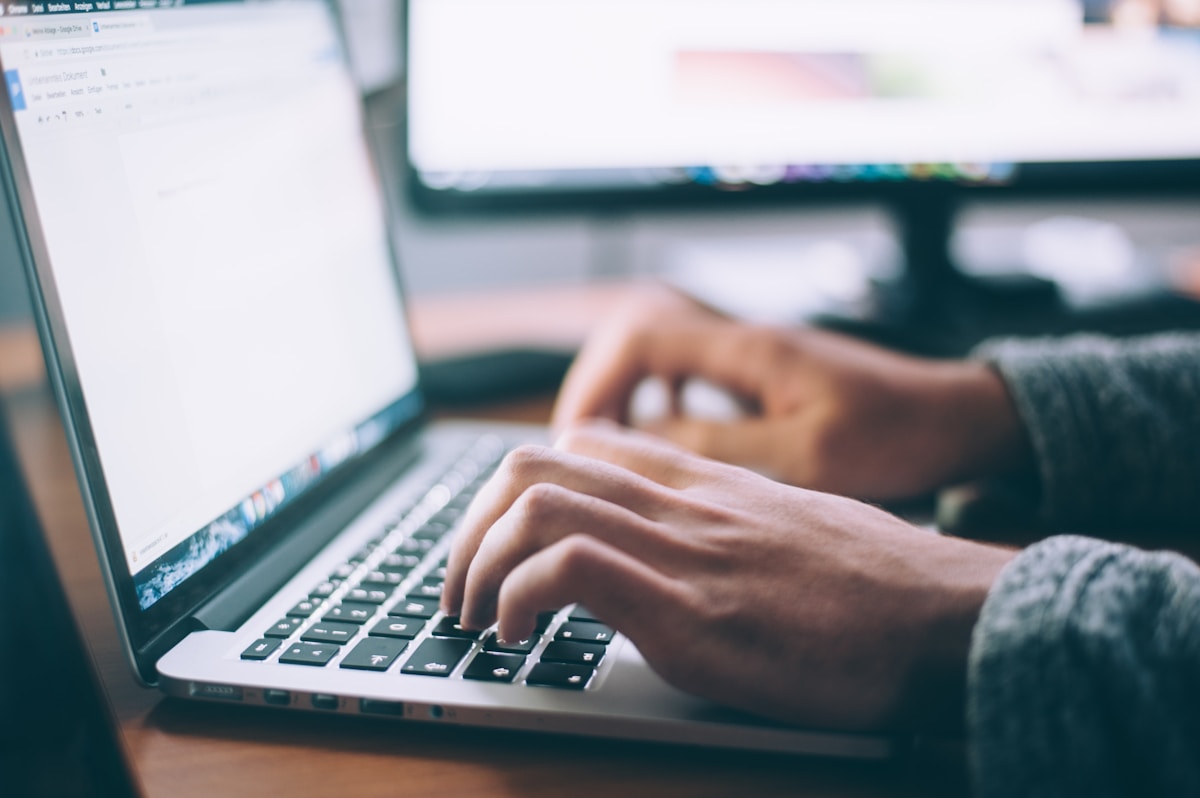 Person reviewing content on a laptop with a trust checkmark badge overlay