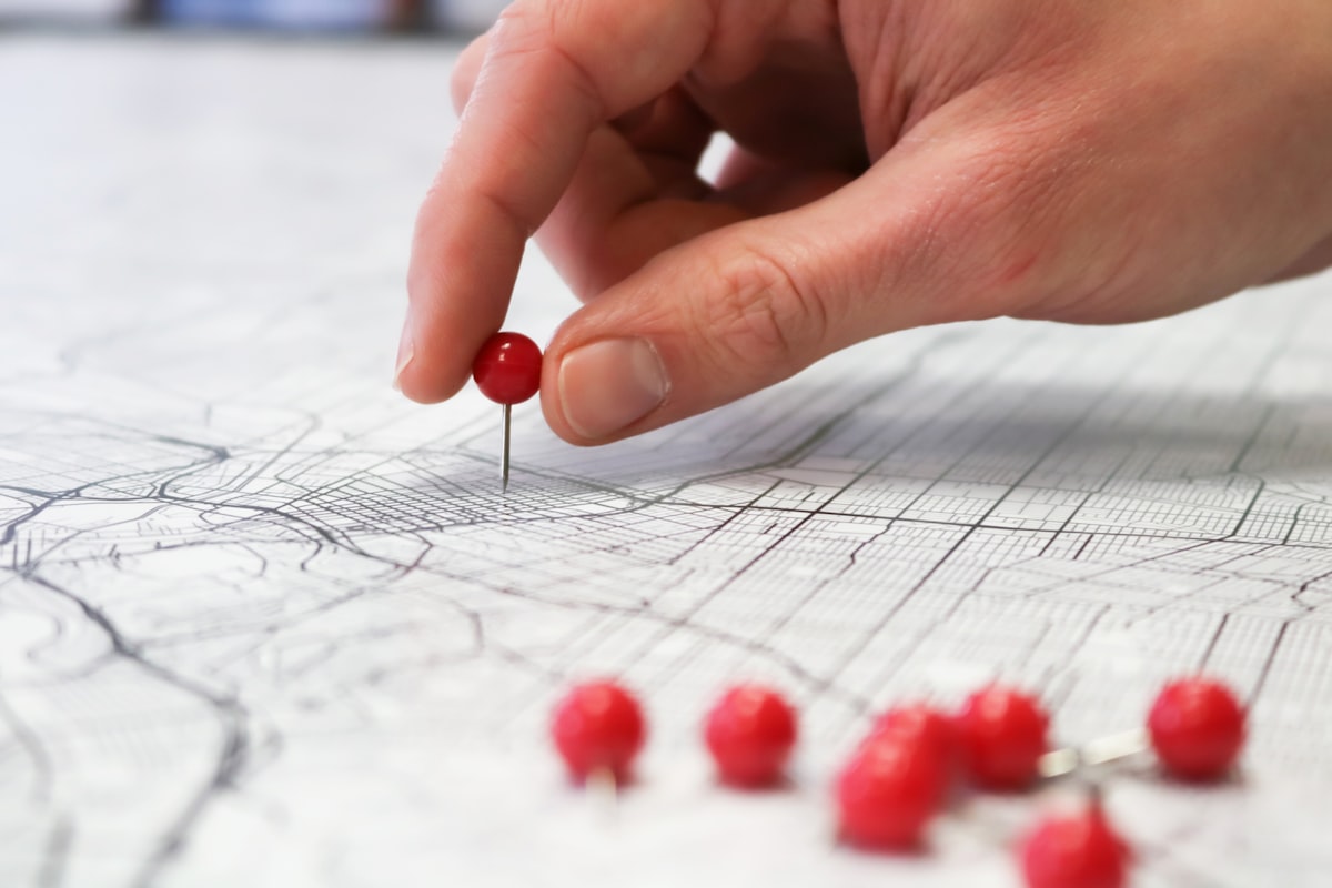 Hand placing a pin on a city map, representing local SEO