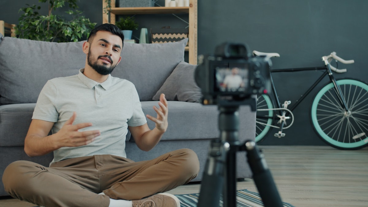Person recording video content with a camera on a tripod