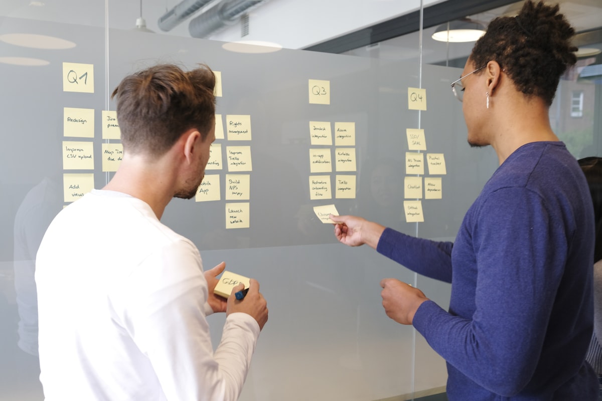 Two people collaborating at a whiteboard in a professional setting